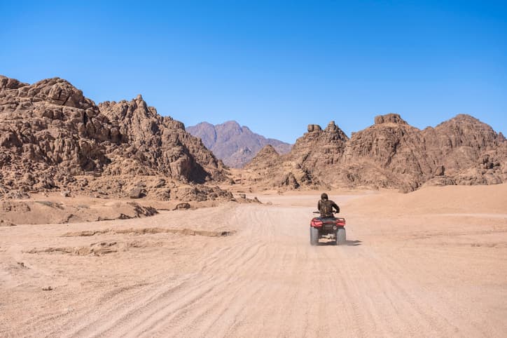 an individual riding an ATV in the desert.