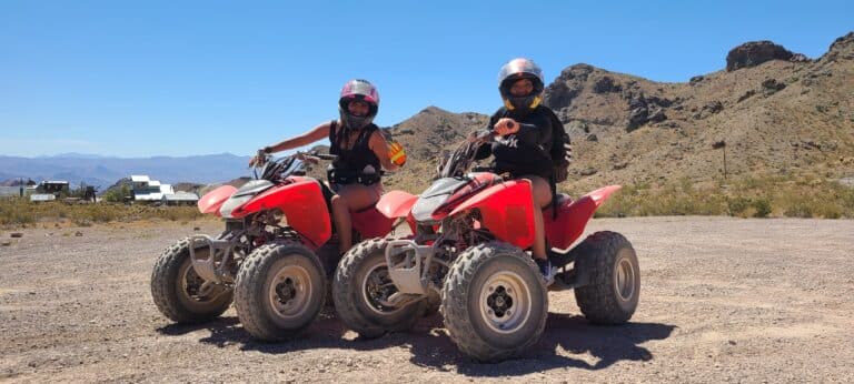 Discover epic Nevada ATV adventures as two helmeted riders explore rocky deserts near Las Vegas under a clear blue sky. #ATVTours.