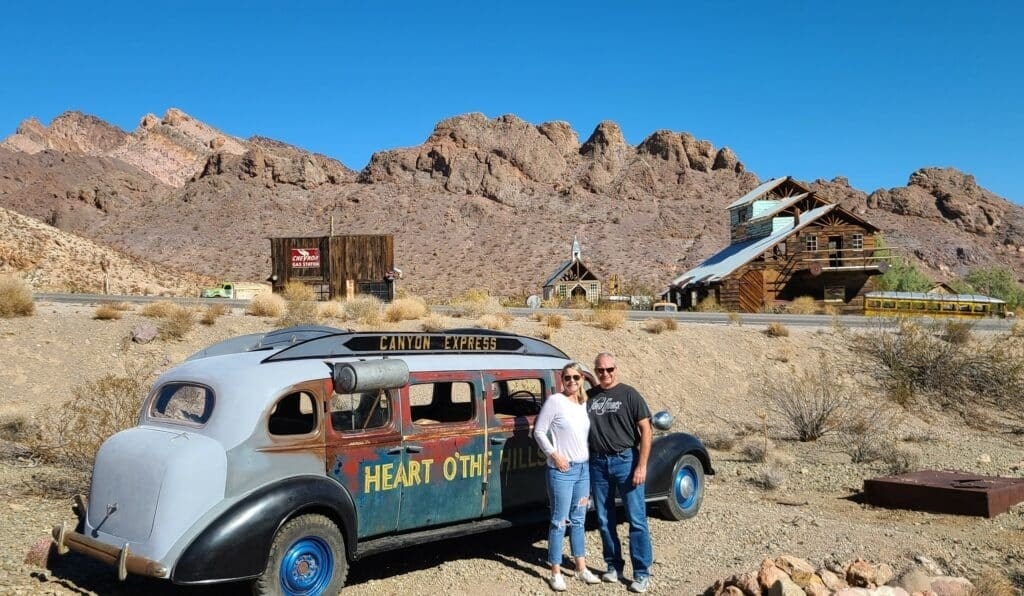 A couple in front of an old vehicle during an Awesome Adventure tour.