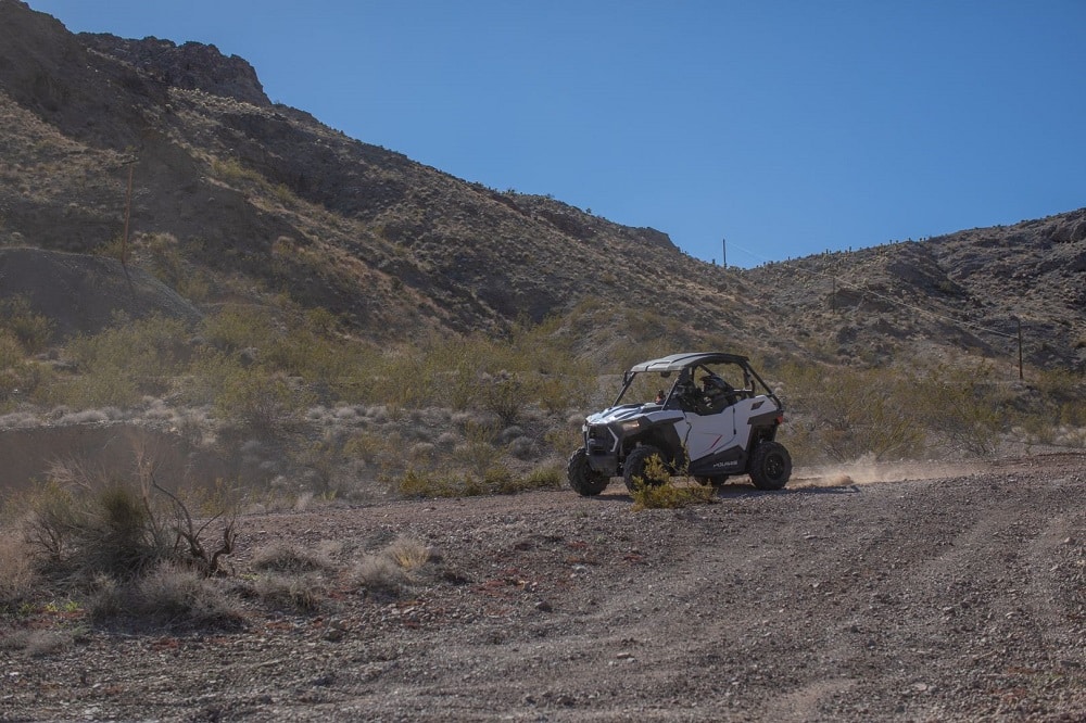 The side of a white RZR from Awesome Adventures while on a trail ride.