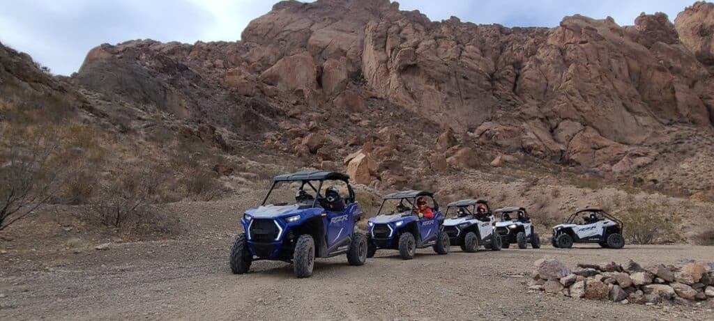 A row of people in their RZRs on an Awesome Adventure tour.