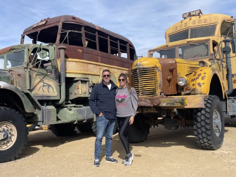 Couple smiles by vintage buses; explore Las Vegas faded colors on a sunny day with thrilling Colorado River ATV tours in Nevada.