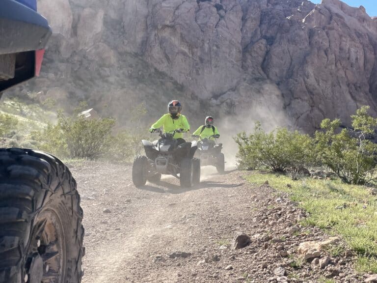 In vibrant neon yellow, adventurers ride ATVs through Nevadas rugged terrain. Explore Las Vegas tours & Colorado River thrills today!.
