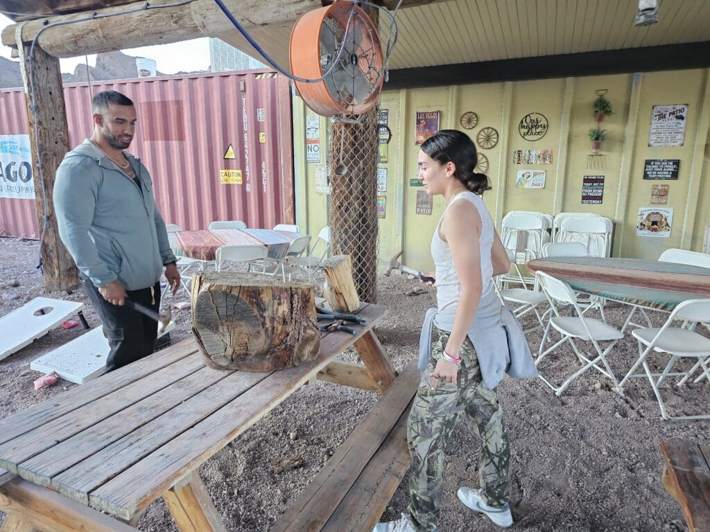 In rustic Nevada, near Las Vegas and the Colorado River, two people engage in axe-chopping by an RZR off-road adventure hub.