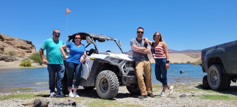 Experience Nevada adventure: four explore a lakeside by ATV with Las Vegas-inspired RZR rides and Colorado River views.