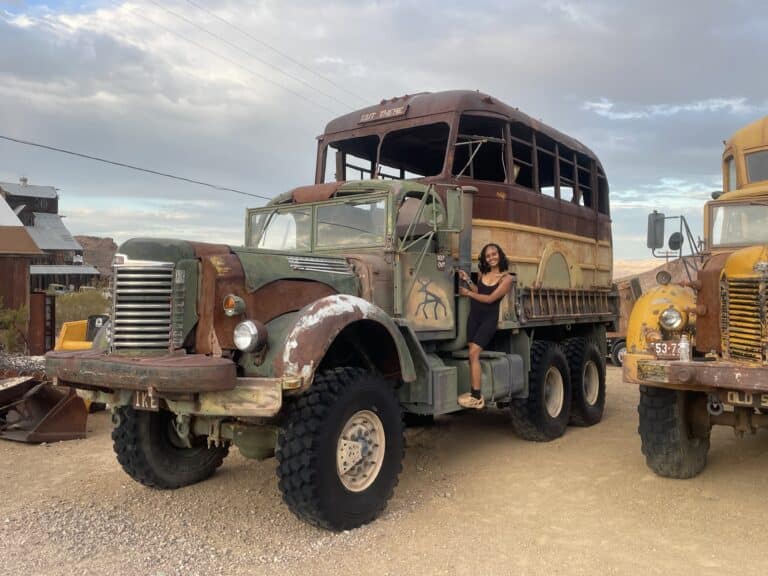 A woman unwinds on a vintage military truck near Las Vegas, perfect for ATV tours and Ghost Town sightseeing in Nevada.