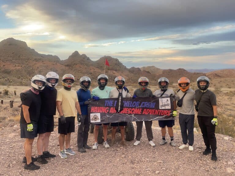 Nine adventurers in helmets and casual gear explore Nevadas rocky terrain near Las Vegas, ready for ATV tours or Ghost Town sightseeing.