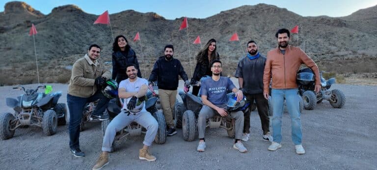 Adventurers with ATVs near Las Vegas, exploring Nevada trails, enjoy a warm sunset glow on an Outdoor Adventures Nevada tour.
