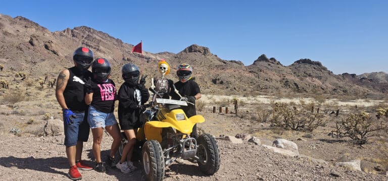 Explore Nevadas rocky desert near Las Vegas on an ATV tour! Ride past mountains with friends, a flag-flying ATV, and a quirky skeleton.
