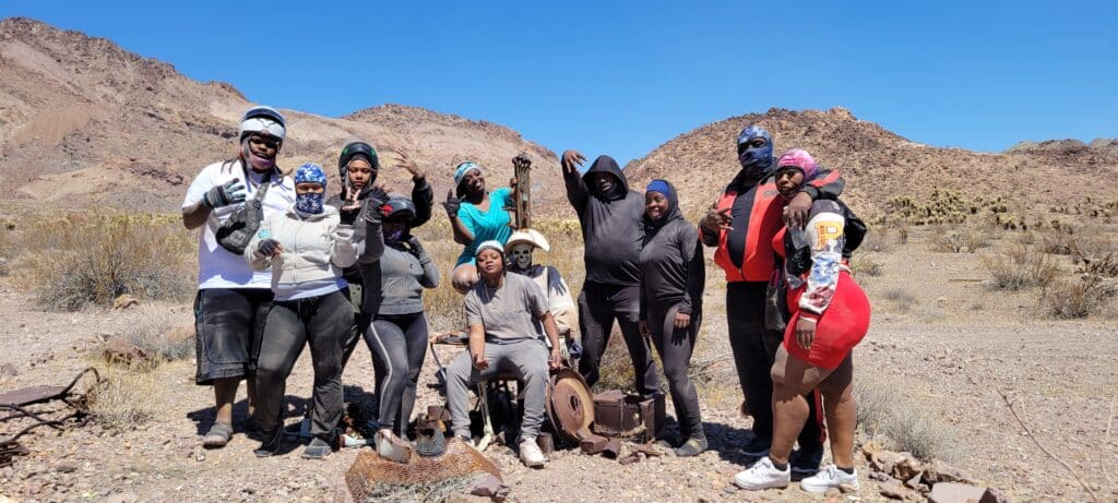 Ten friends pose in Nevada’s desert near Las Vegas and the Colorado River after a fun ATV tour, smiling for the camera.