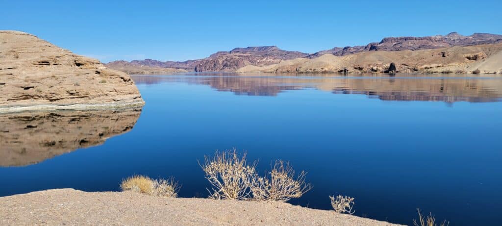 Discover Nevadas serene desert landscape on a thrilling Las Vegas RZR tour to the Colorado River, with lakes, rocky hills, and vibrant vegetation.