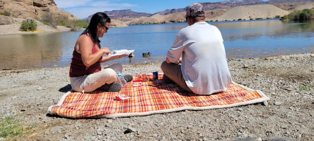 Enjoy a sunny picnic by the Colorado River near Las Vegas, Nevada, with stunning mountain views and outdoor adventure nearby.