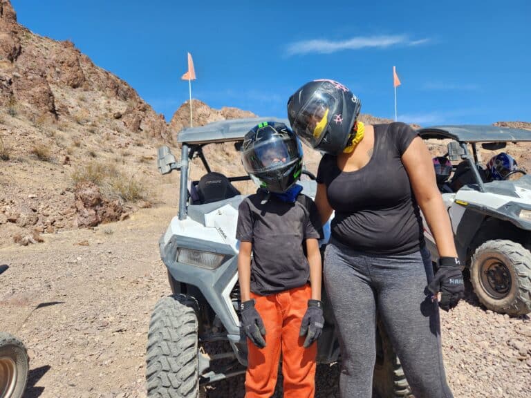 A child and adult in helmets prepare for a thrilling ATV tour near the Colorado River, Las Vegas, Nevada desert adventure.