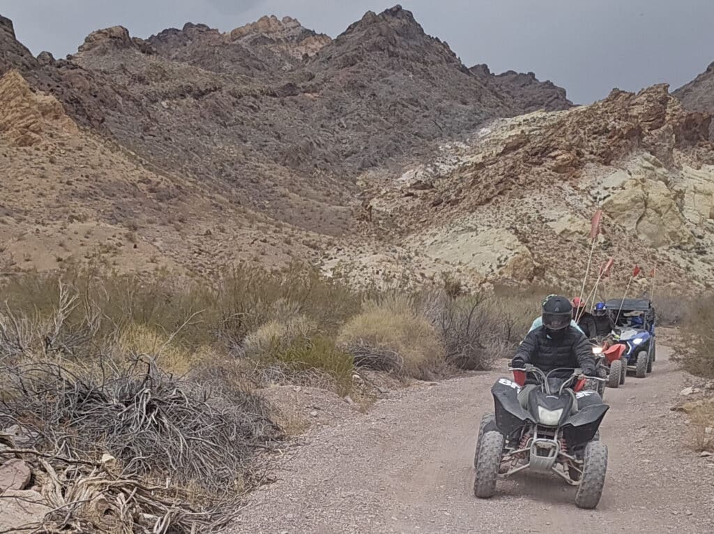 Adventurers enjoy an ATV tour near Las Vegas, riding rugged desert trails in Nevada with views of rocky mountains and the Colorado River.