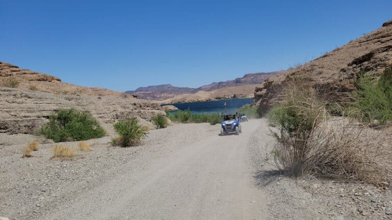 Experience an ATV tour near Las Vegas on a blue RZR, racing along desert trails by the Colorado River and Nevada mountains.