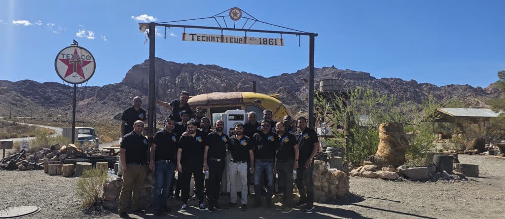 A group in matching black shirts stands at Techatticup Ghost Town near Las Vegas, Nevada, perfect for ATV tours and desert sightseeing.