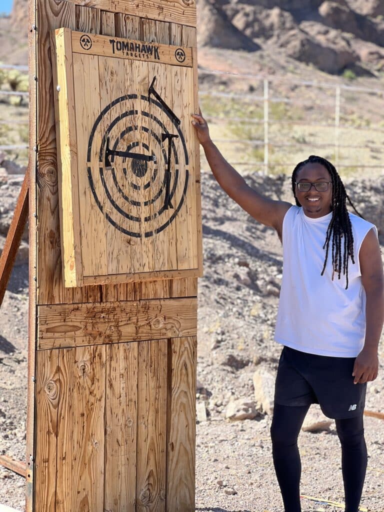 Smiling confidently beside a wooden target in Eldorado Canyon, this Las Vegas adventurer embodies the spirit of a Nevada RZR tour.