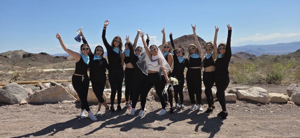 Bridal party in matching outfits celebrates near the Colorado River, Nevada, after an exciting Las Vegas RZR off-road tour.