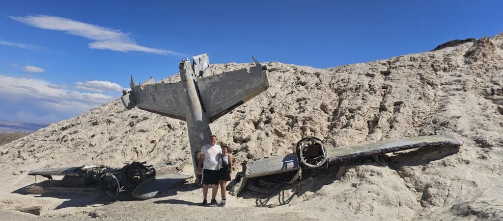 Two people explore a crashed airplane wreckage in Nevada’s desert near the Colorado River on an epic ATV tour from Las Vegas.