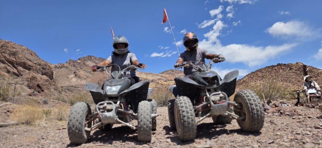 Adventure seekers in Nevada ride ATVs near Las Vegas on a rocky desert trail, exploring Ghost Towns by the Colorado River.