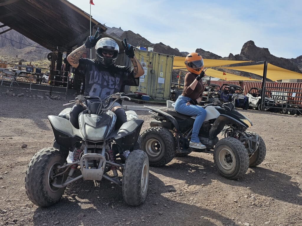 Two riders on ATVs enjoy a dusty Nevada trail near Las Vegas with scenic mountains, perfect for RZR tours and Ghost Town adventures.