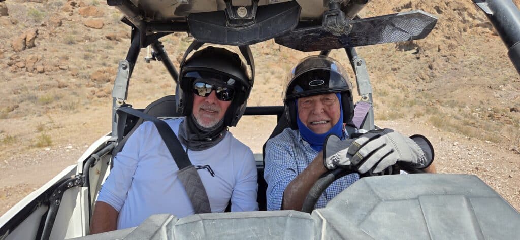 Two men in helmets enjoy a RZR off-road ride near Las Vegas and the Colorado River, exploring Nevada’s rugged desert terrain.