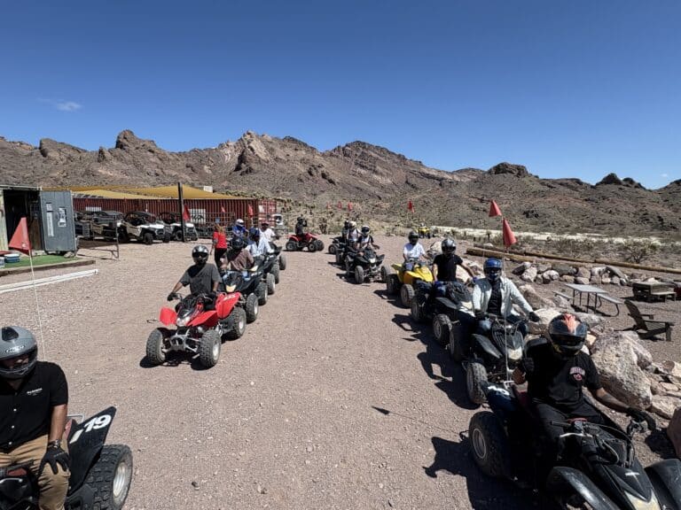 Adventurers in helmets line up on ATVs for a thrilling Las Vegas desert tour near the Colorado River in Nevada.