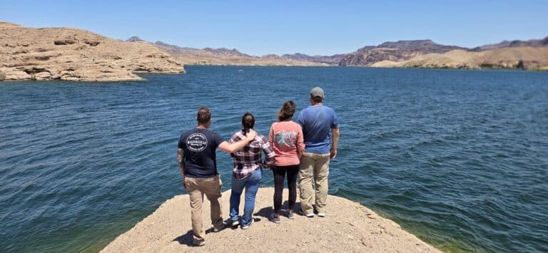 Four friends admire the Colorado River near Las Vegas, Nevada, after an exciting RZR ATV off-road adventure.