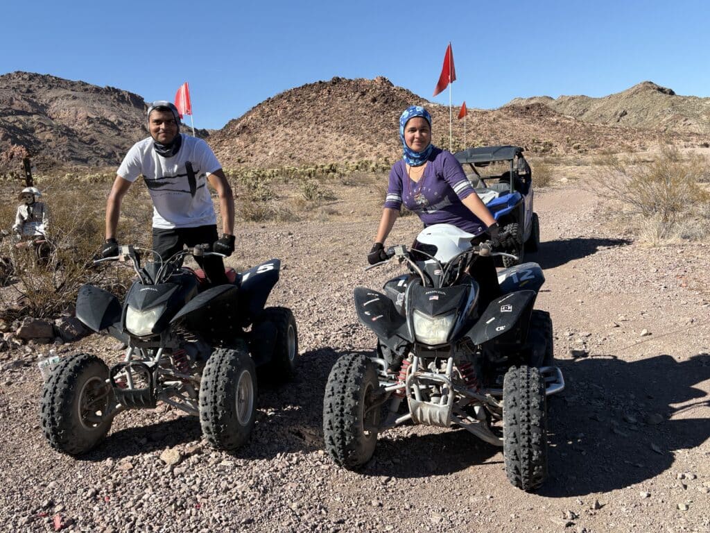 Adventurers pose with ATVs on a rocky Nevada desert trail near Las Vegas, ready for an exciting off-road tour.