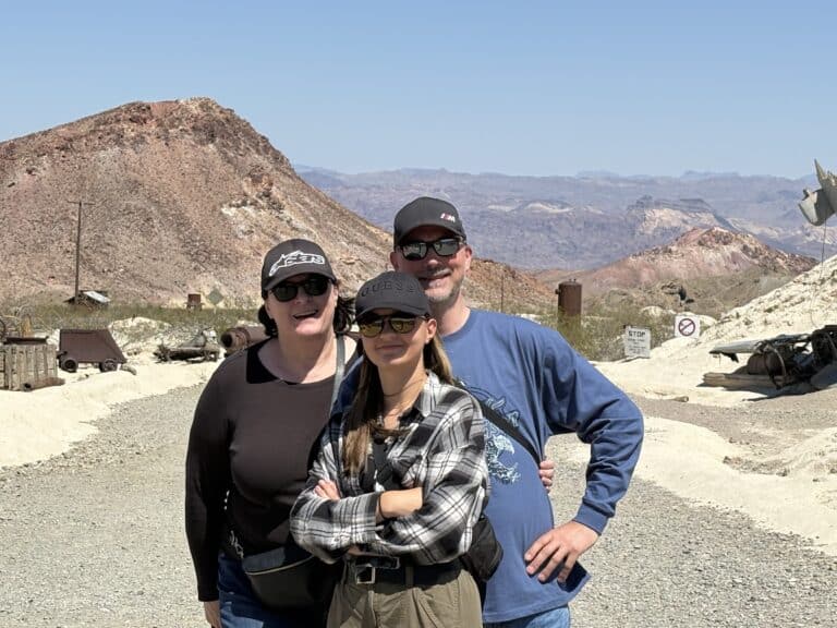 Three friends in hats and sunglasses pose on a Nevada desert trail near Las Vegas after a thrilling RZR ATV tour by the Colorado River.