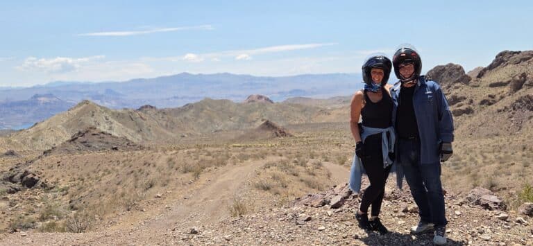 Two adventurers in helmets explore a rocky Nevada trail near Las Vegas, with Colorado River views—perfect for ATV tours or RZR rides!.