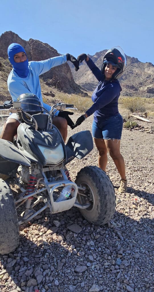Making a heart with their hands, two friends enjoy an ATV tour near Las Vegas and the Colorado River in Nevada’s rugged outdoors.