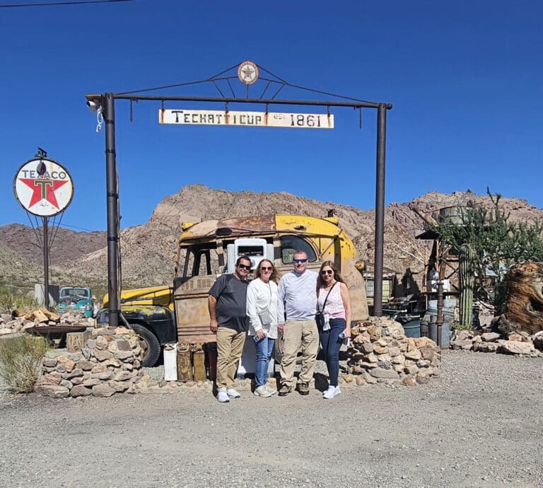 Smiling group at Techatticup Ghost Town near Las Vegas, Nevada, with desert views—perfect for ATV tours & Colorado River sightseeing.