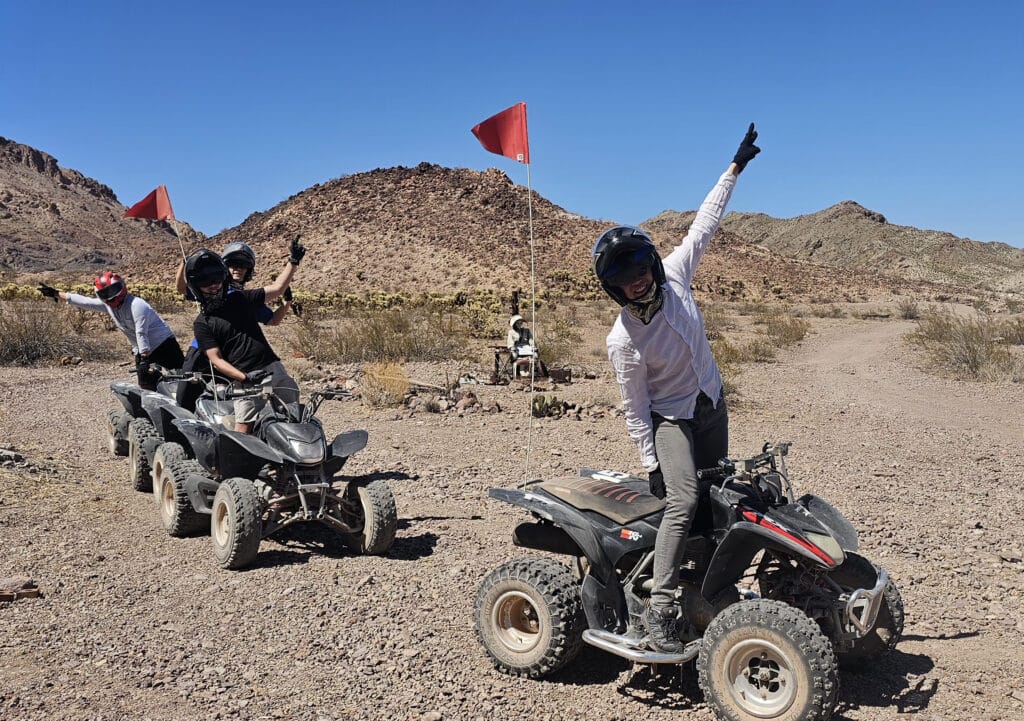 Adventure-seekers enjoy a Nevada ATV tour near Las Vegas, riding rocky trails with red flags and scenic Colorado River views.