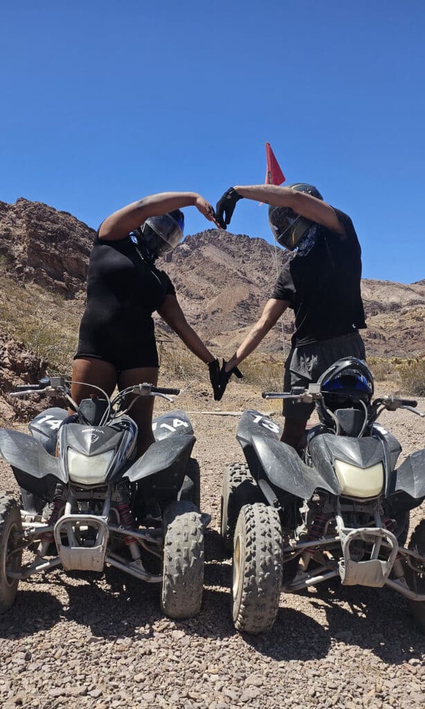 Riders in black gear form a heart on ATVs amid Nevada’s rocky desert near Las Vegas and the Colorado River on an ATV tour.