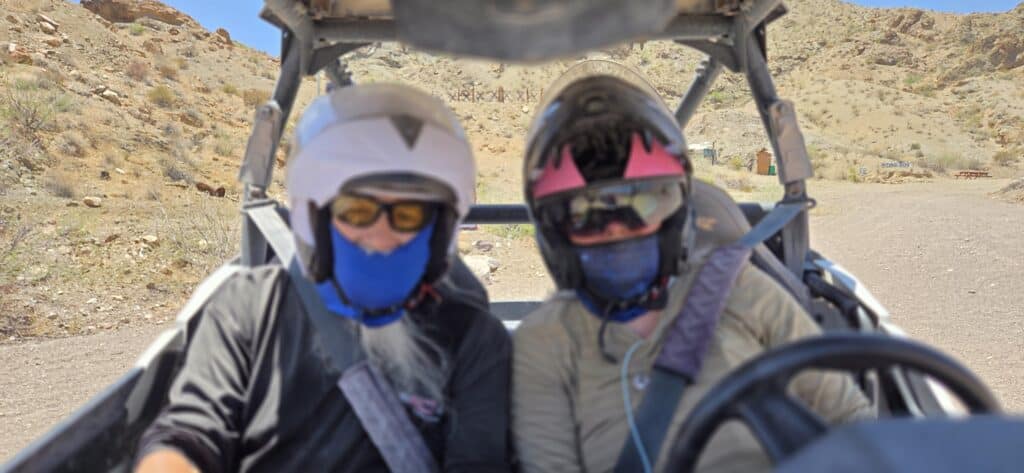 Adventurers in helmets and sunglasses gear up for a thrilling RZR off-road ride near Las Vegas in Nevada’s rocky desert.