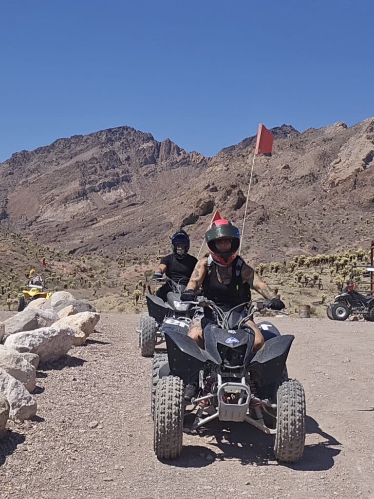 ATV riders explore a dusty desert trail near Las Vegas, Nevada, with rocky mountains and cacti—Epic RZR off-road adventure!.