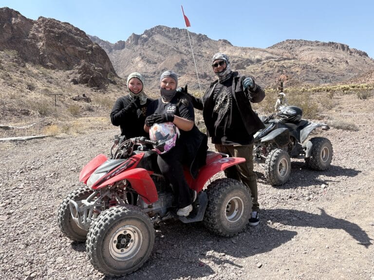 Adventurers in black gear pose with ATVs near Las Vegas, Nevada, ready for an exciting ATV tour by the Colorado River.