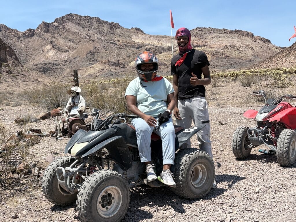 Adventurers pose with ATVs in the Nevada desert near the Colorado River on a thrilling Las Vegas RZR off-road tour.
