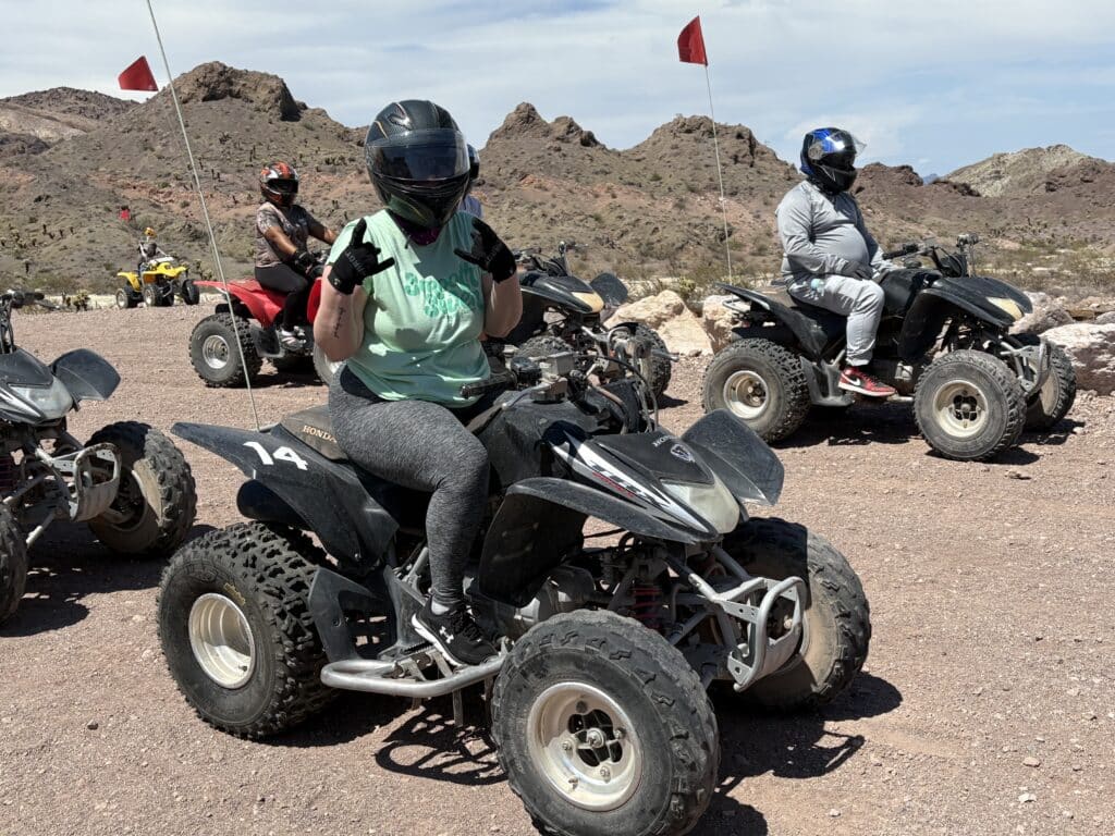 Adventurers on ATVs pose in Nevada’s rocky desert near Las Vegas, ready for an exciting off-road ATV tour.