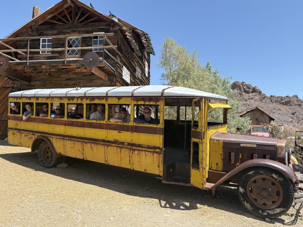 A group tours a vintage yellow school bus near a Nevada ghost town, perfect for ATV rides by the Colorado River near Las Vegas.