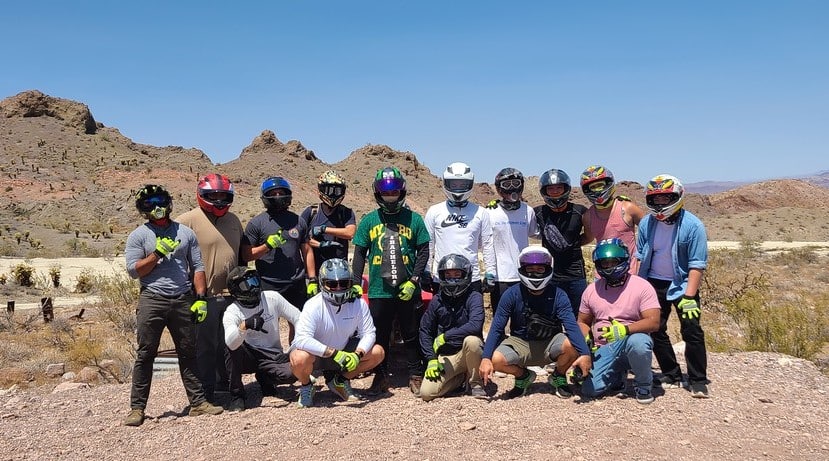 Group of 15 in helmets and gear pose in the Nevada desert on a Las Vegas ATV tour near the Colorado River and Ghost Towns.