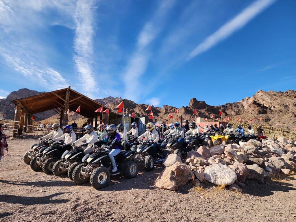 Riders in helmets line up on ATVs in Nevada, ready for Las Vegas ATV tours near the Colorado River and Ghost Town sights.