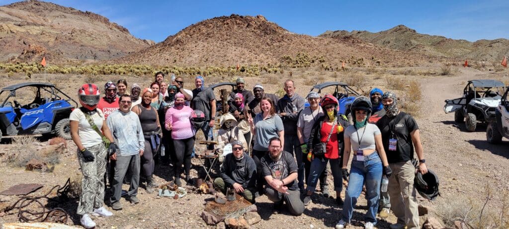 A group enjoys a Las Vegas ATV tour in Nevadas desert, with rocky hills and RZR off-road vehicles near the Colorado River.