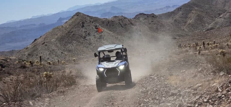 Experience an exciting RZR off-road ride near Las Vegas, Nevada—dusty desert trails, mountain views, and a red flag flying high!.