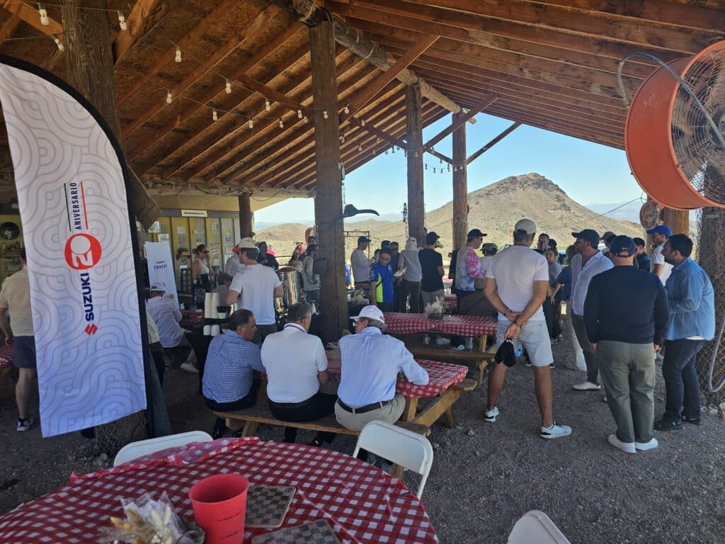 A group enjoys a picnic under a pavilion near Las Vegas, Nevada, after ATV tours by the Colorado River; Suzuki flag flying high.