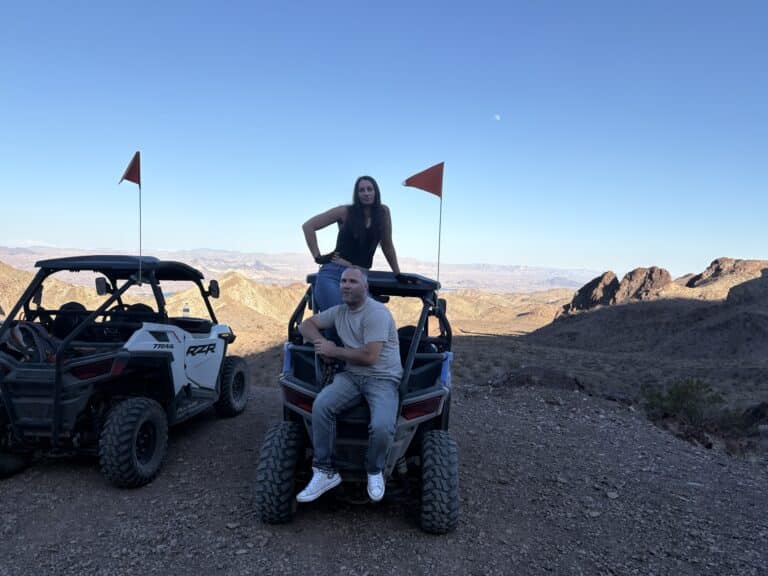 Couple enjoys a RZR off-road ride near Las Vegas, Nevada, with rocky desert views by the Colorado River—perfect for ATV tours!.