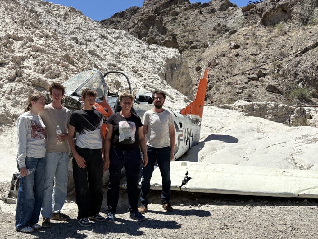 Five people pose by a weathered plane wreck near Las Vegas, Nevada—perfect for ATV tours and Colorado River adventures.