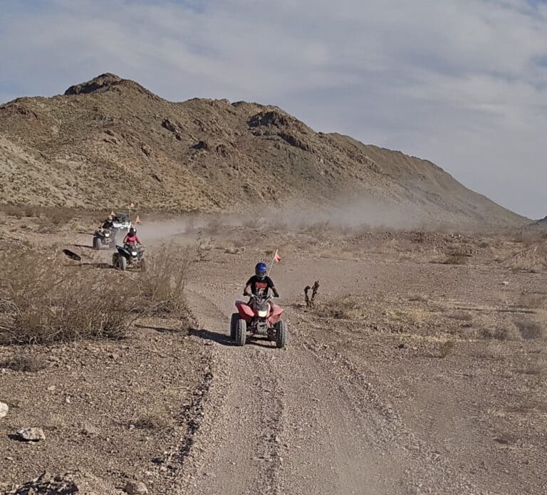Experience thrilling ATV tours near Las Vegas on dusty Nevada trails, riding past rocky hills and desert views toward the Colorado River.