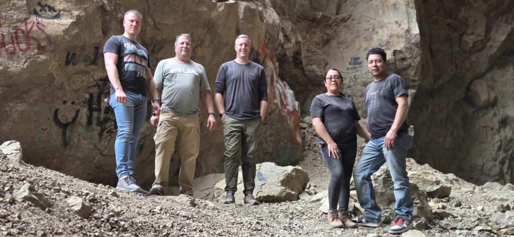 Group poses in a graffiti cave near the Colorado River, Nevada, after RZR off-road Las Vegas ATV tour adventure.